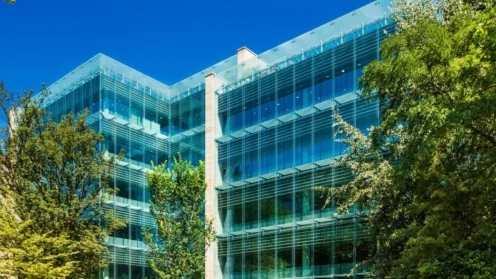Foto des Gebäudes. Zu sehen sind fünf Stockwerke und viel Glas.