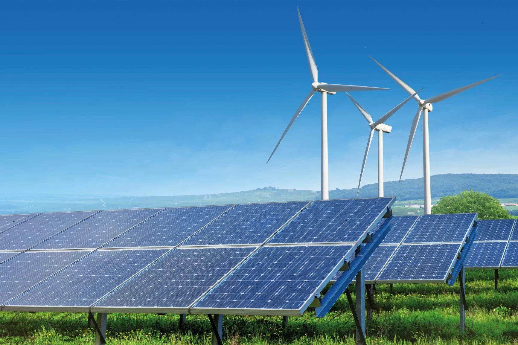 Solaranlage mit Windrädern im Hintergrund