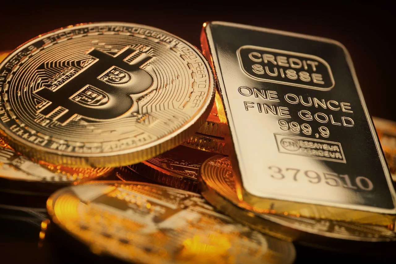 Bitcoin-Muenzen und Goldbarren