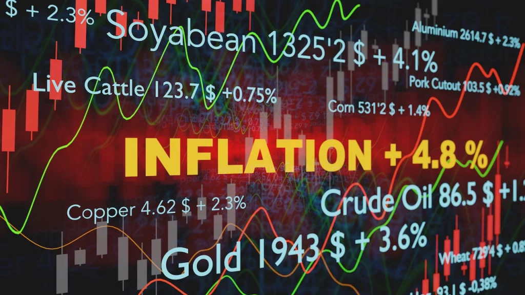 Die Schrift Inflation sticht orange hervor im Hintergrund sieht man Aktienkurse