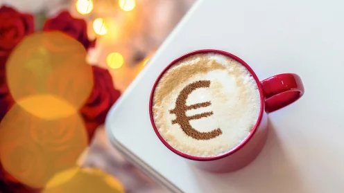 Capucchino-Taste mit einem Eurozeichen aus Kakaopulver auf dem Milchschaum