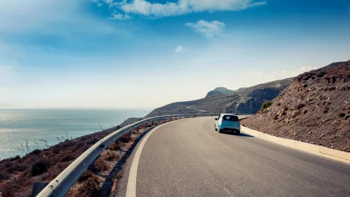 ein Auto fährt auf einer Straße am Meer