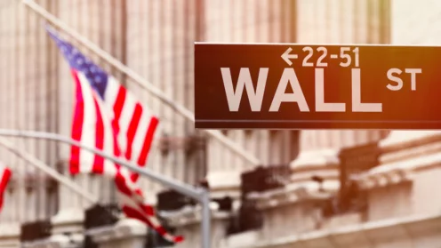 Bild vom Wall Street Schild mit einer US Flagge im Hintergrund