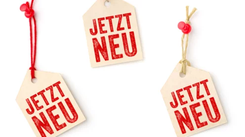 Drei Anhänger mit dem Aufdruck Jetzt Neu