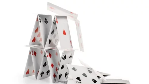 Abgestürztes Kartenhaus. Fallende Karten isoliert auf weiß, Clipping-Pfad enthalten