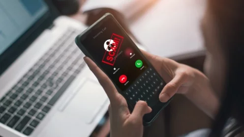 Smartphone, auf dessen Display das Wort Scram erscheint und Laptop
