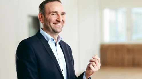 Lars Gentz vor dem Hintergrund eines Büro-Flurs