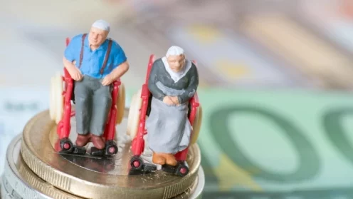 Altes Ehepaar im Rollstuhl, auf Euroscheinen. Altersarmut, Pflegebedürftigkeit, Sorgen