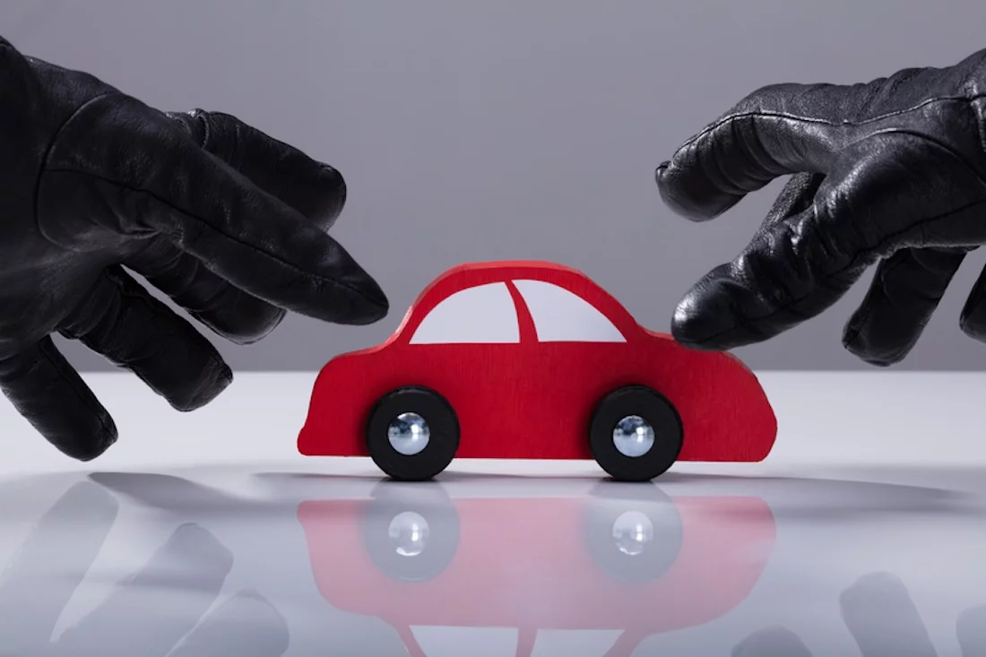 Autodiebstahl, Kfz, Nahaufnahme der Hand eines Diebes, der Handschuhe trägt und ein rotes Auto stiehlt
