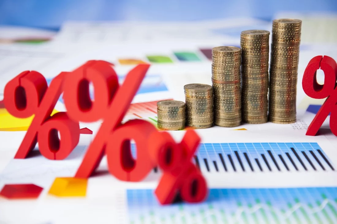 Finanzkonzept. Grafik aus Münzstapeln mit roten Prozentzeichen auf Berichten.