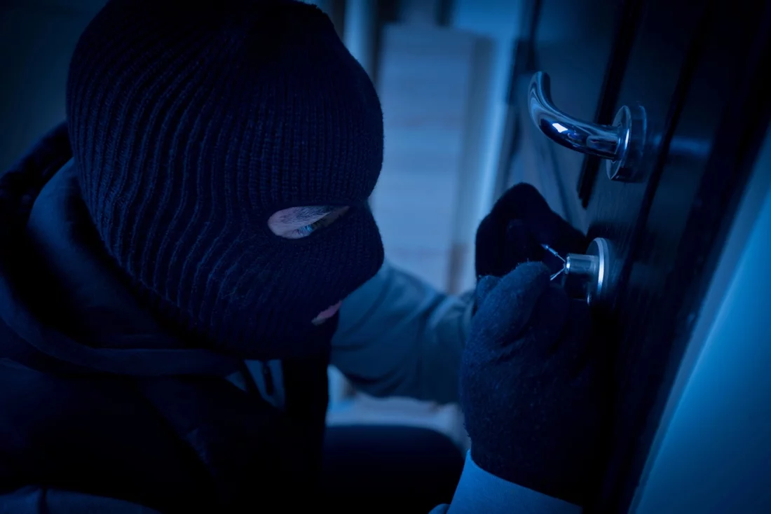 Einbrecher, Dieb knacken ein Türschloss, Sicherheit, Hausratversicherung