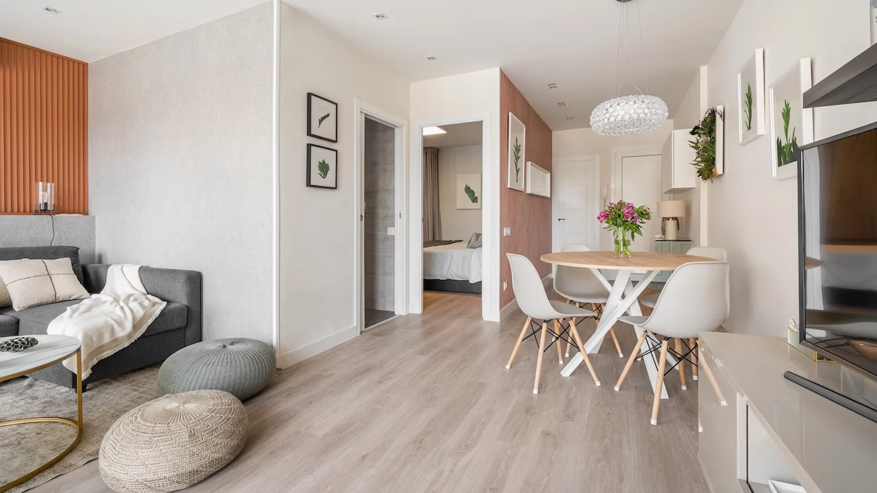 Comfortable seating area with a terracotta color wall with a sofa and poufs near the dining area in the living room studio. Concept of a modern European interior.