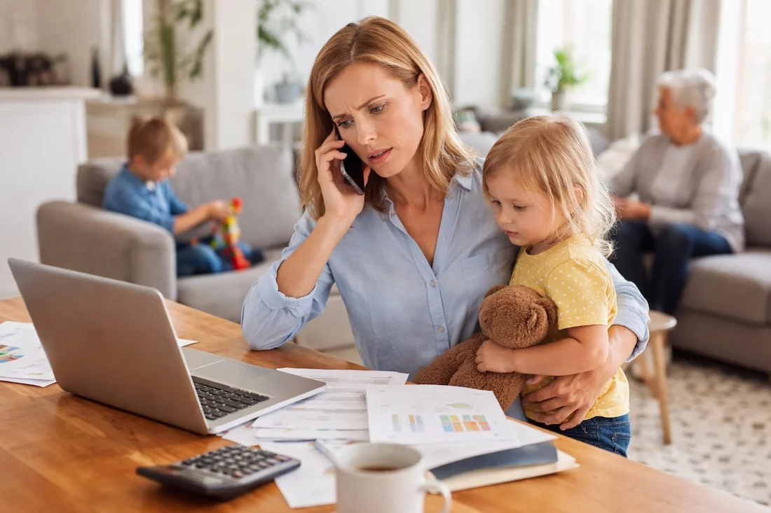 Homeoffice, Care-Arbeit, Pflege, Gender Pension Gap, Gender Pay Gap, Mutter mit Kind am Laptop, im Hintergrund betreute ältere Frau