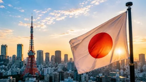 Japanische Flagge vor der Skyline von Tokio mit dem Tokyo Tower im Hintergrund.