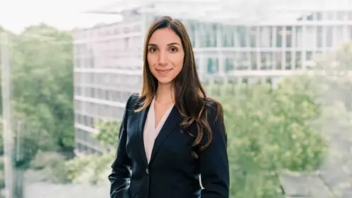 Maria Angela Ciriello vor dem Hintergrund eines Bürohauses und Bäumen.