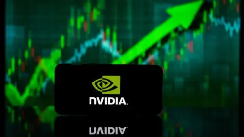 Smartphone mit NVIDIA-Logo auf dem Display vor einem etwas verschwommenen grünen Aktienkurs, der nach oben zeigt.