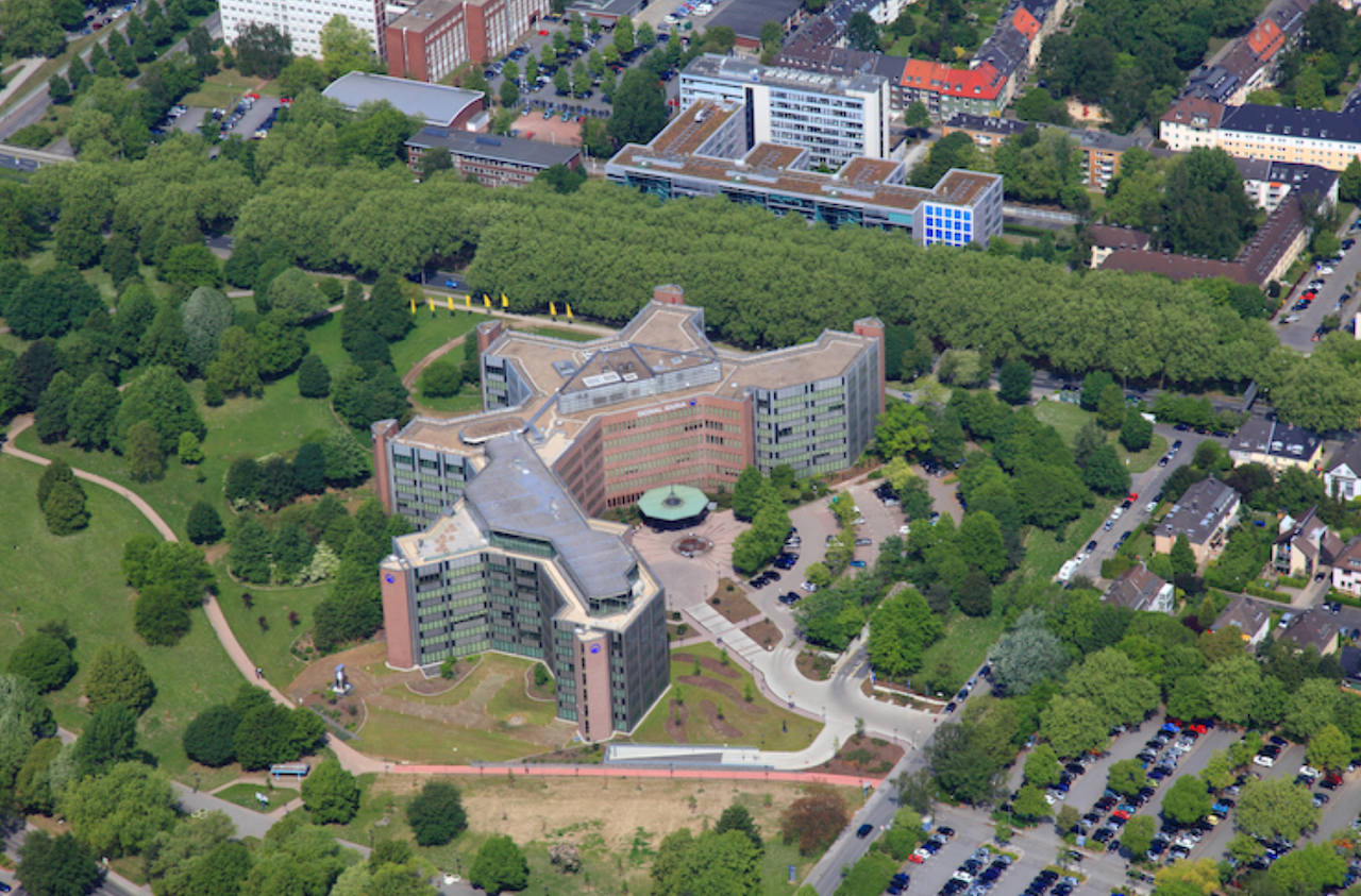 Ein großes Gebäude im Gründen aus der Vogelperspektive fotografiert.