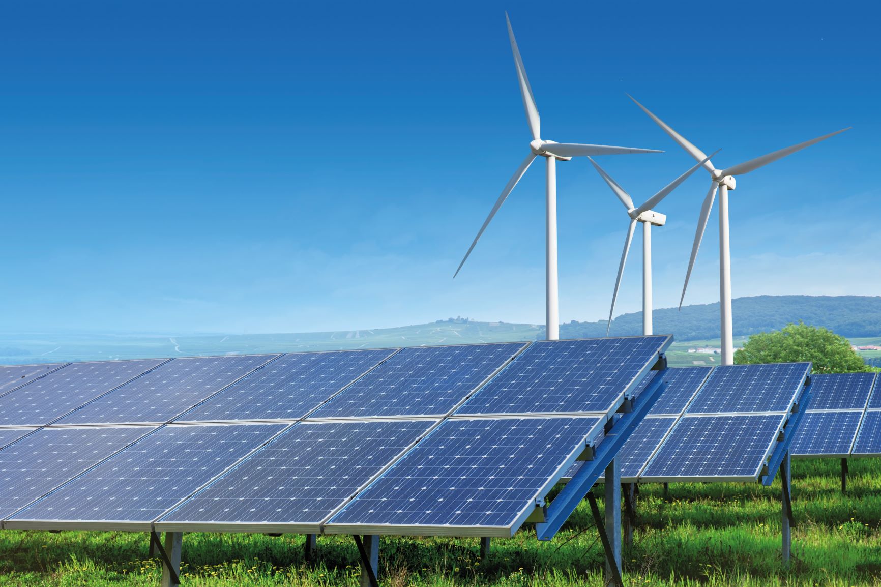 Solaranlage mit Windrädern im Hintergrund