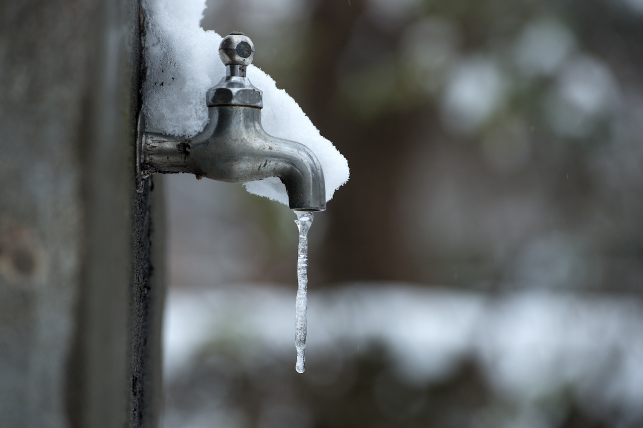 Vereister Wasserhahn mit Schnee