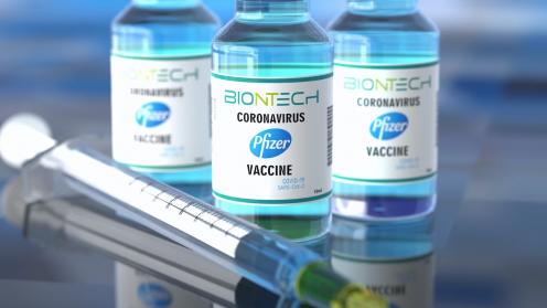 Drei Fläschchen des BionTech Impfstoffs und eine Spritze