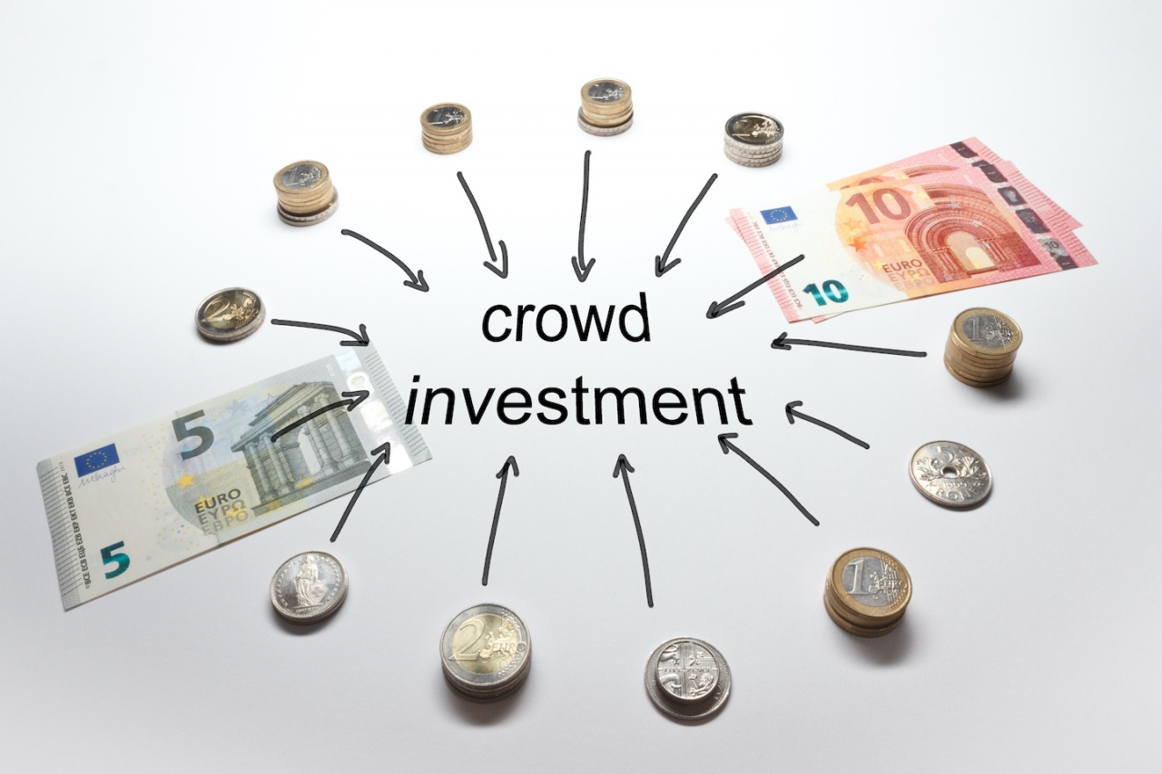 Kreis aus Geldscheinen und Münzen um das Wort Crowdinvesting