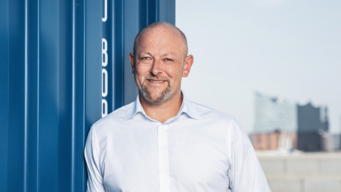 Solvium Geschäftsführer Jürgen Kestler lehnt an einem blauen Container