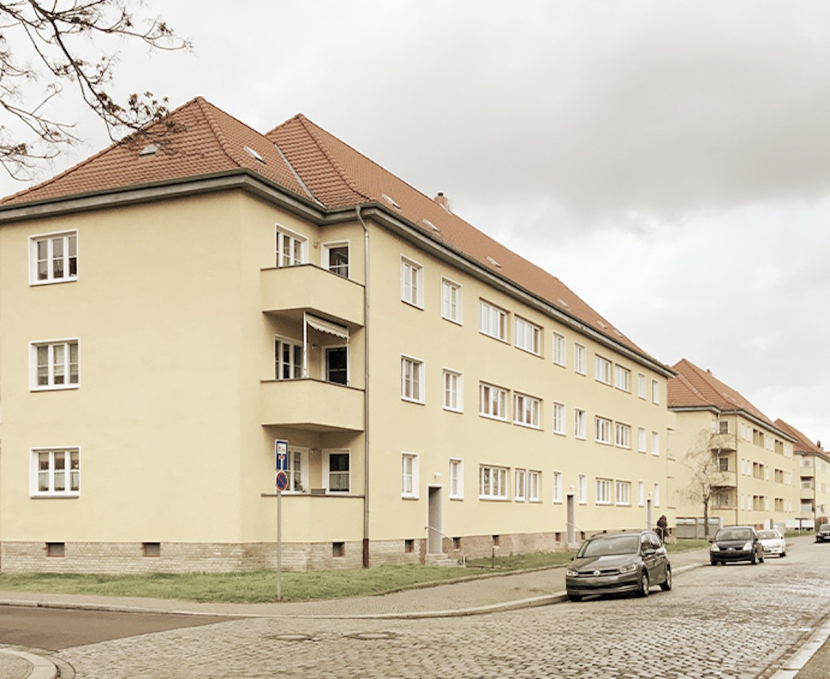 Von AS Unternehmensgruppe erworben: Gelbe Mehrfamilienhäuser mit rotem Dach.