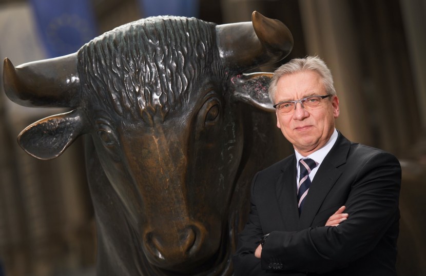 Klaus Nieding steht neben dem Bronce-Bullen der Börse Frankfurt