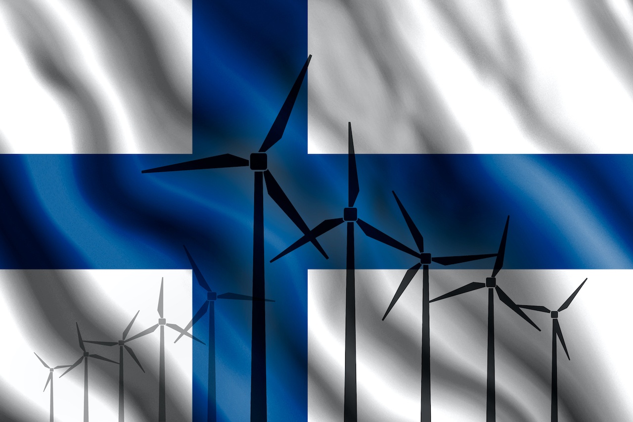 Windräder vor der Flagge Finnlands, wo Commerz Real investiert