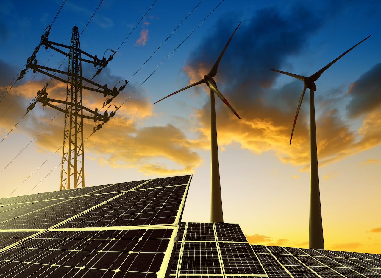 Windräder, Solaranlagen und Strommast in der Dämmerung als Symbolbild für Klimavest Commerz Real