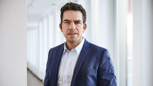 Exporo Chef Brunke vor dem Hintergrund eines Büroflurs