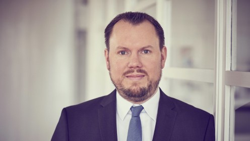 Jan-Peter Schmidt, Vorstand der Deutschen Zweitmarkt AG, vor einem gläsernen Büro