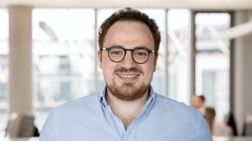 Crowddesk Geschäftsführer El Mallouki vor dem Hintergrund eines Großraumbüros