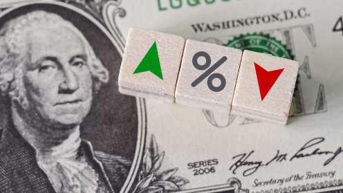 Dollarscheine und darüber ein grüner und ein roter Pfeil und ein Prozentzeichen