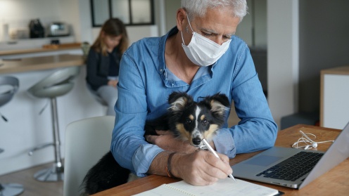 Alster Mann mit Hund auf Schoss arbeitet von zu Hause