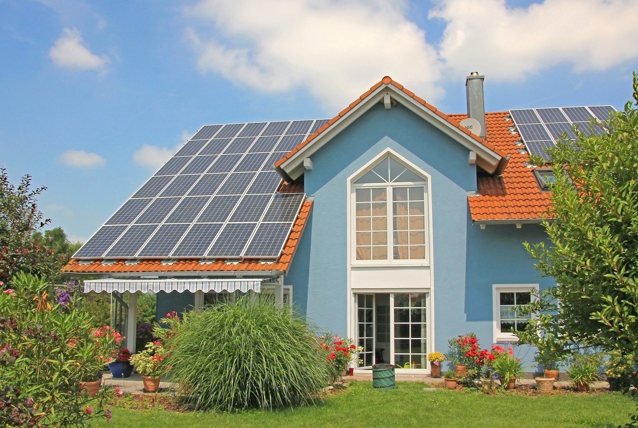 Modernes, blaues neues Haus mit Garten und Solaranlage