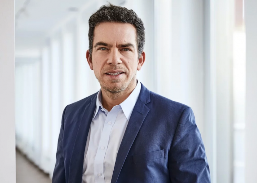 Exporo Co-CEO Simon Brunke vor dem Hintergrund eines Büroflurs