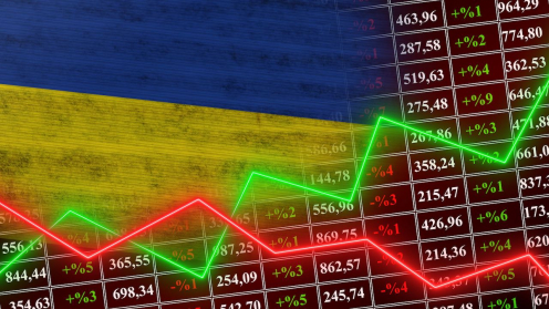 eine grüne und eine rote Linie verlaufen in Zacken vor einer Ukraine Flagge und Börsenkursen