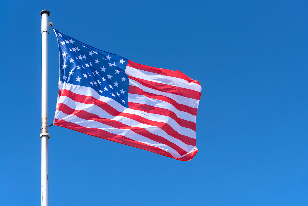 Die US-amerikanische Flagge vor blauem Himmel