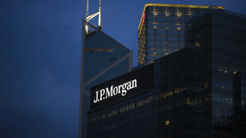 das JP Morgan Gebäude ist ein Hochhaus. Es steht im Dunkeln und man sieht die JP Morgan Schrift hell erleuchtet