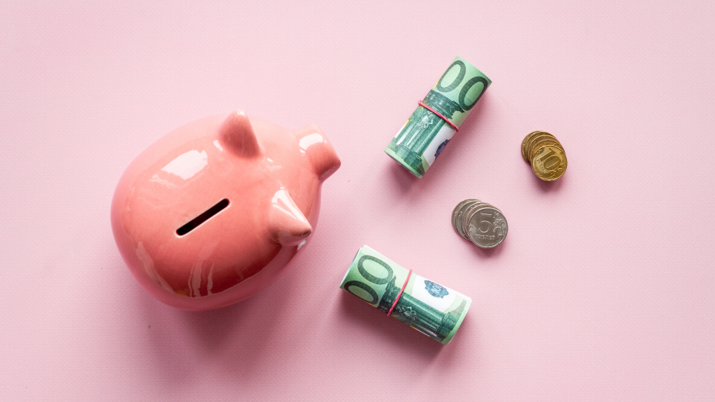Ein Sparschwein von oben und Bargeld, das daneben liegt