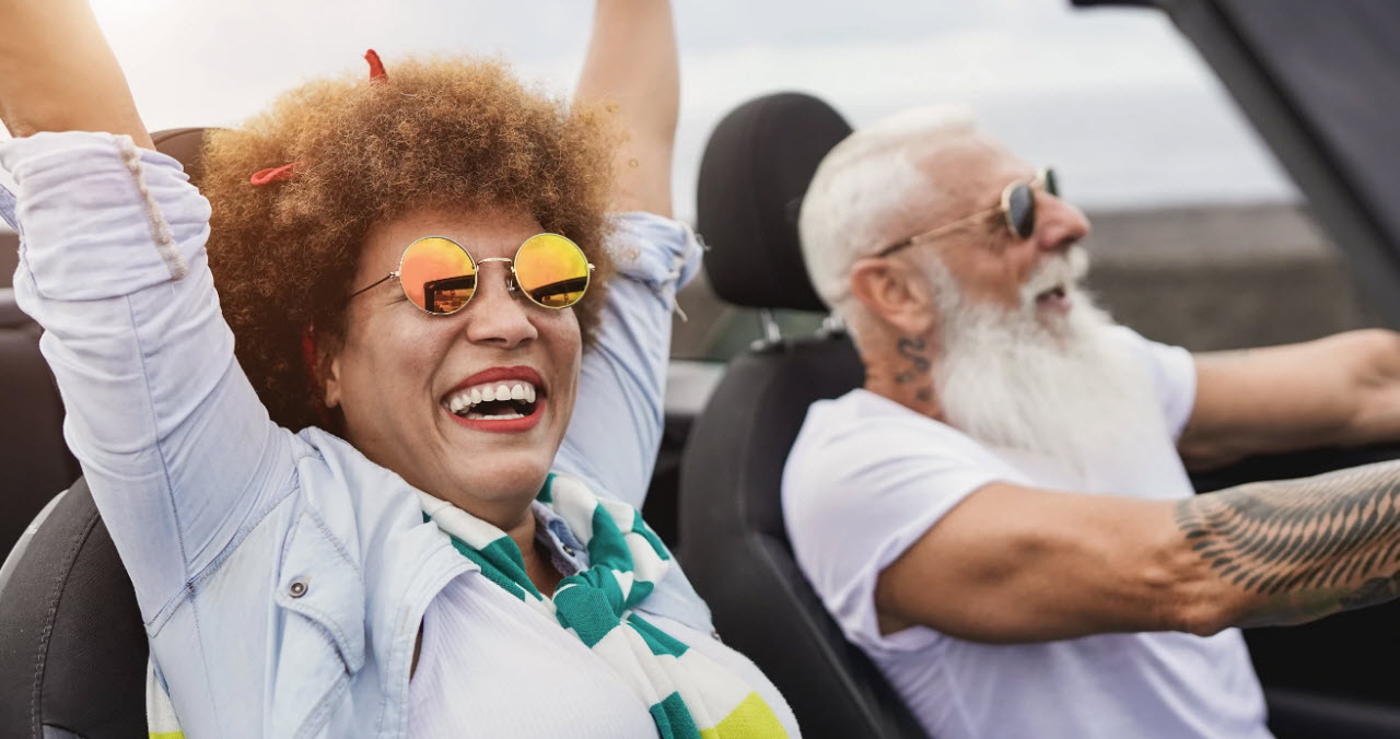 Älteres Ehepaar fährt feiern in einem Cabrio