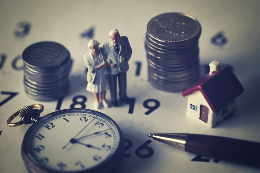 Stoppuhr Geld ein Miniaturhaus ein Kugelhschreiber liegen auf einem Blatt mit Zahlen