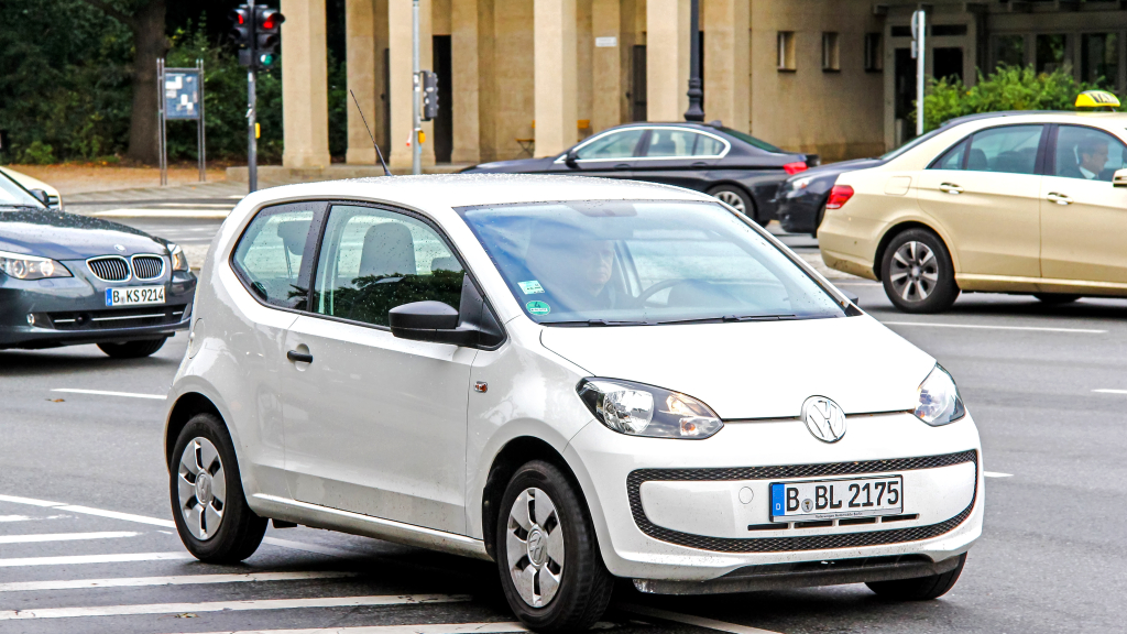 Ein weißer VW Up mit Berliner Kennzeichen fährt auf der Straße