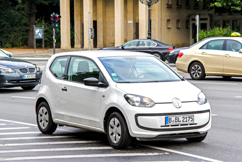 Ein weißer VW Up mit Berliner Kennzeichen fährt auf der Straße