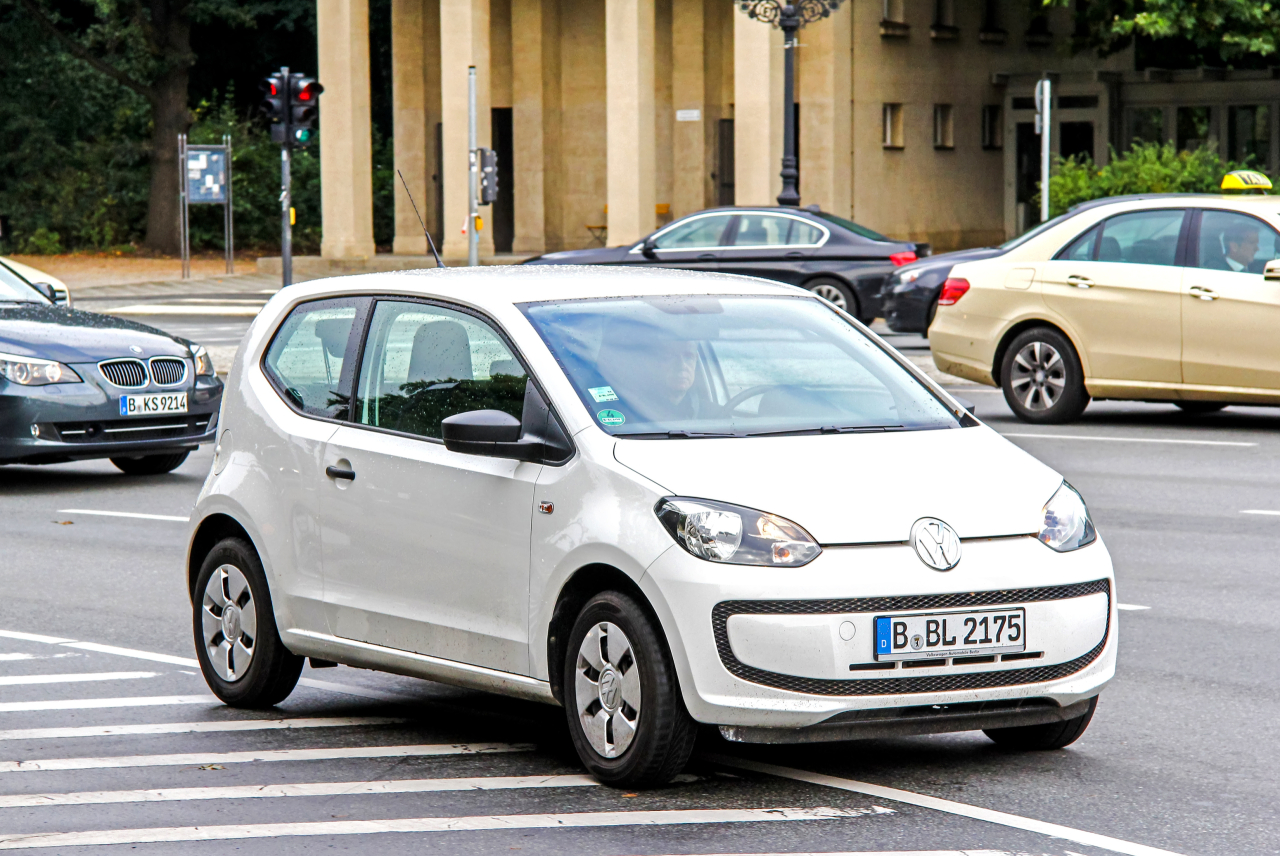 Ein weißer VW Up mit Berliner Kennzeichen fährt auf der Straße
