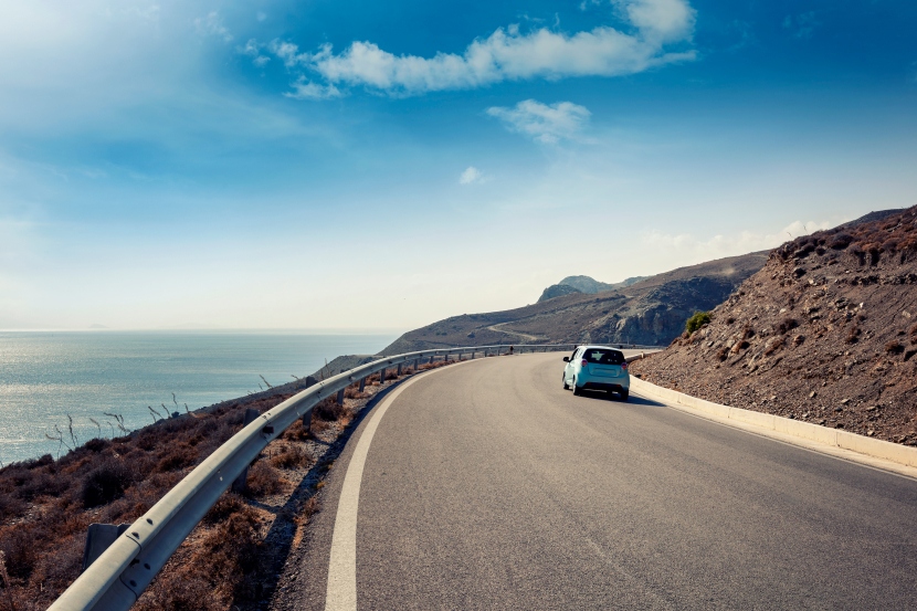 ein Auto fährt auf einer Straße am Meer