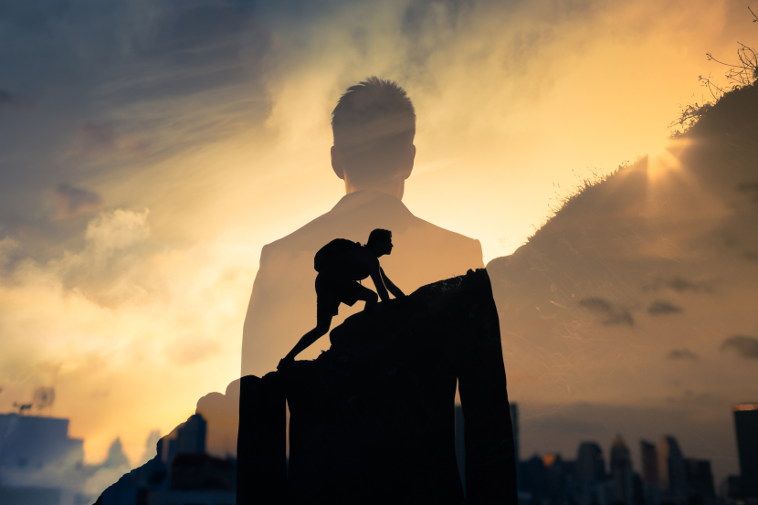 Der Schatten eines Mannes der einen Berg hochklettert darüber der Schatten eines weiteren Mannes