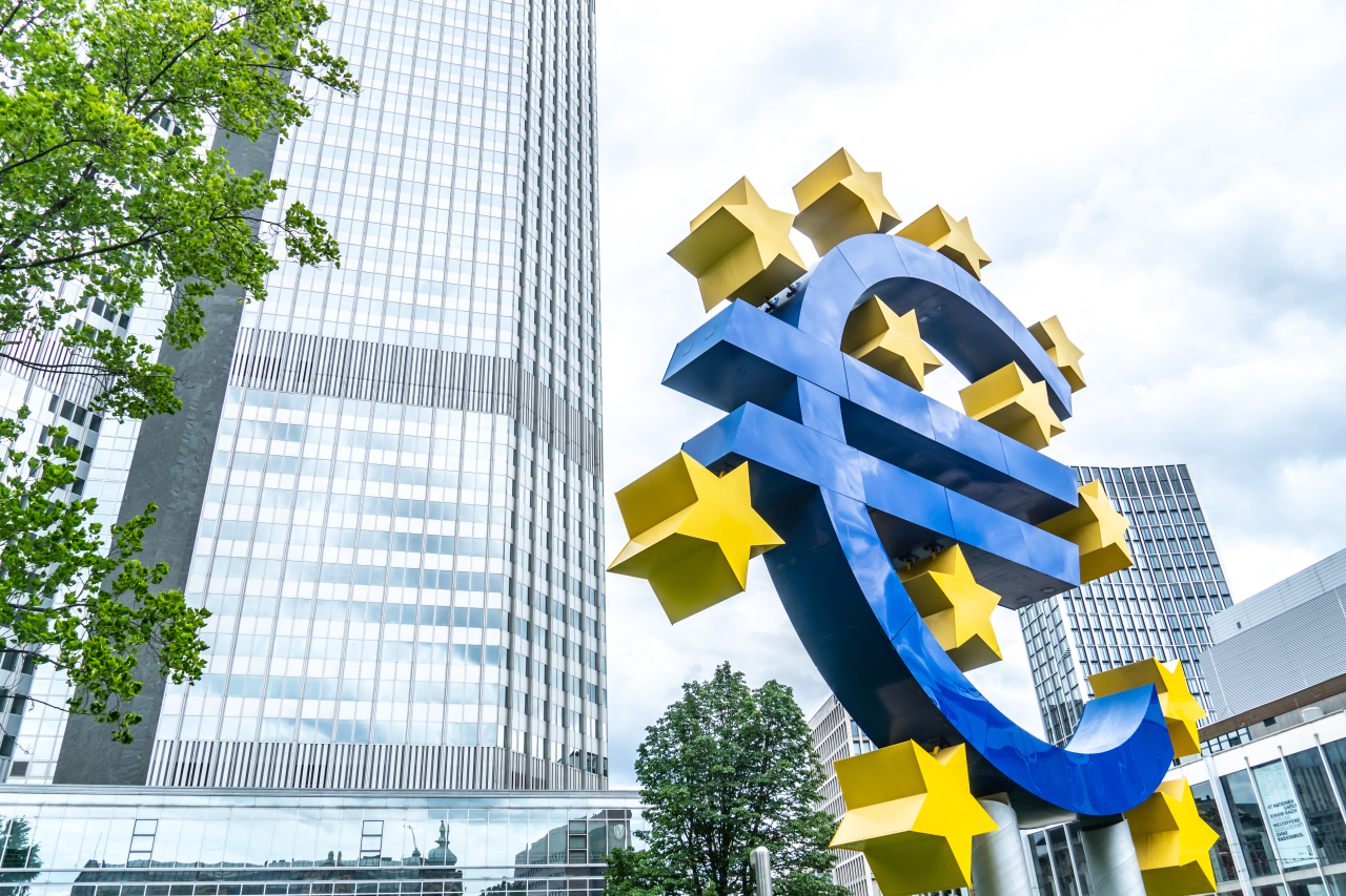 Ein großes blaues Eurozeichen in Frankfurt vor Hochhäusern