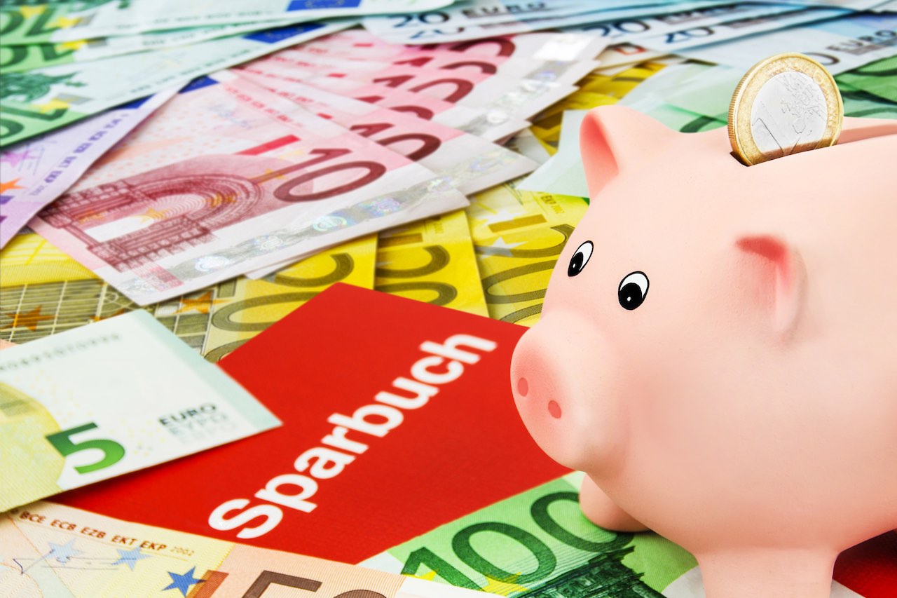 Sparbuch und Sparschwein auf Euro-Scheinen